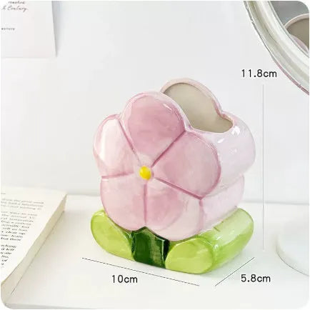 Ceramic floral pen holder box in pink tulip design on a desk.