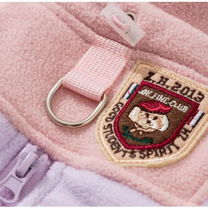 Four-legged fleece pet jacket in colour block design with full zipper and badge patch, sizes S-XXL for cats and small dogs.