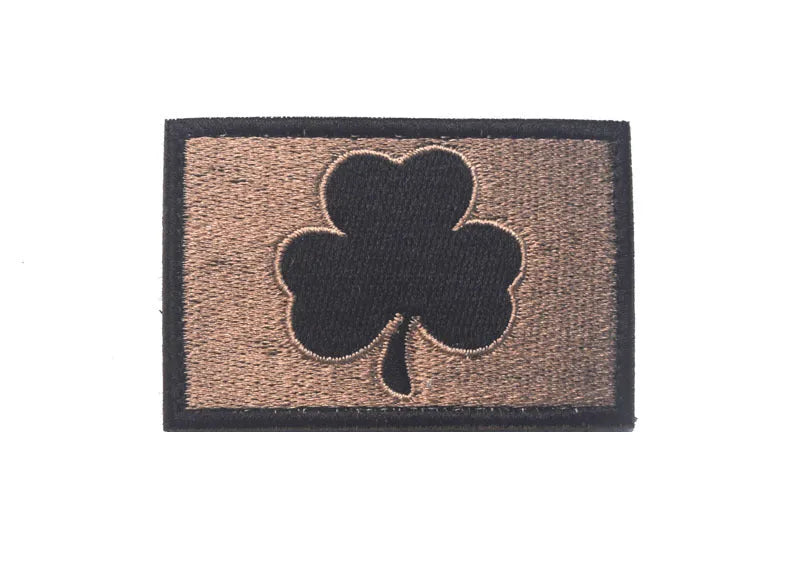 Outdoor embroidered fabric badge with Velcro backing on a green clover design.