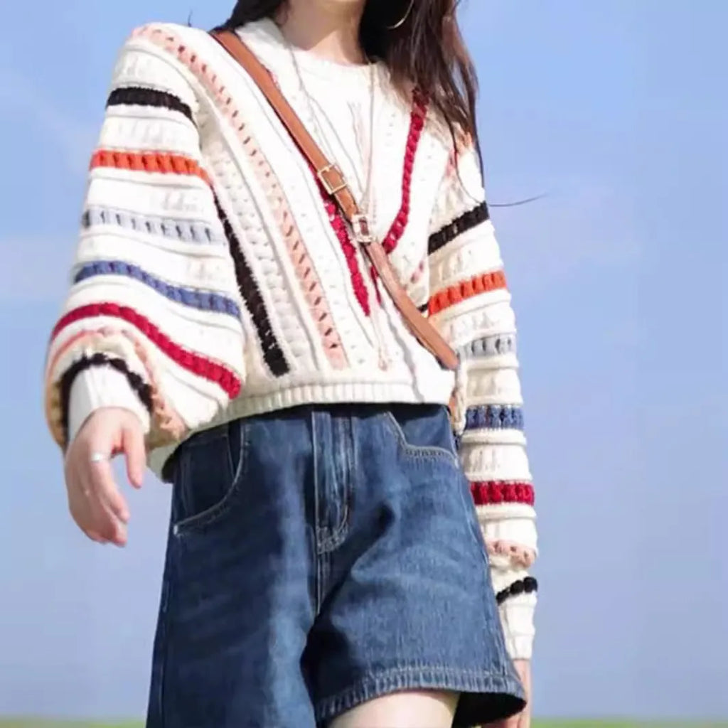 Retro rainbow striped loose fit sweater with batwing sleeves on a hanger.