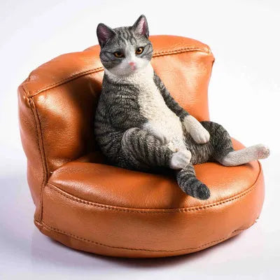 Small resin cat figurine on a sofa, a 1:6 scale car dashboard ornament.
