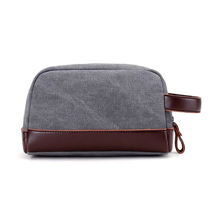 Men's canvas changing wallet in horizontal square shape with soft carry handle and zippered compartments, available in five solid colours.