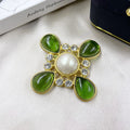 Close-up of a vintage medieval baroque style zinc alloy brooch with a crystal cross centrepiece.