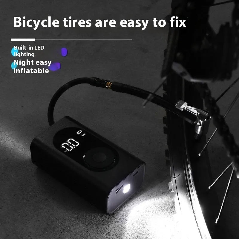 Black portable wireless tyre pump with digital display, LED flashlight, and USB cable on a grey background.