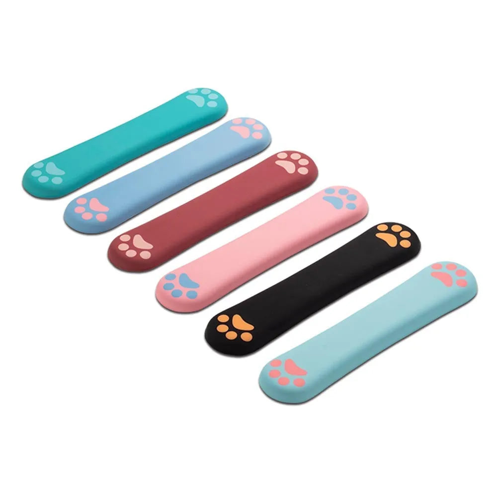 Cat's claw shaped memory foam wrist support pad in black, placed in front of a keyboard.