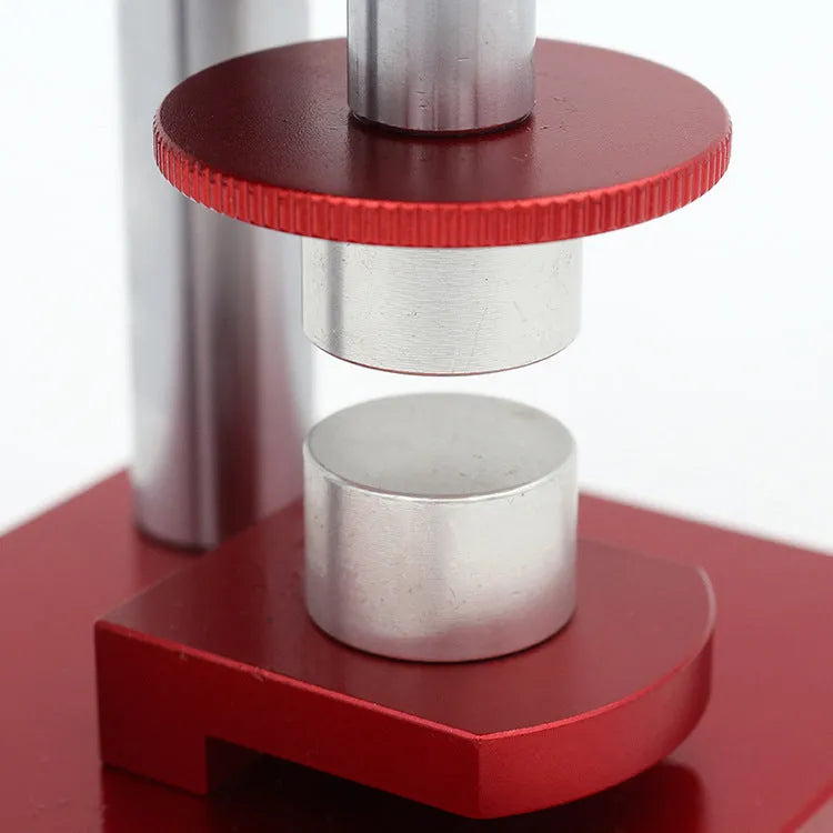 Watch back cover press tool, a spiral cap presser machine, shown with a set of 20 plastic moulds for different watch sizes.