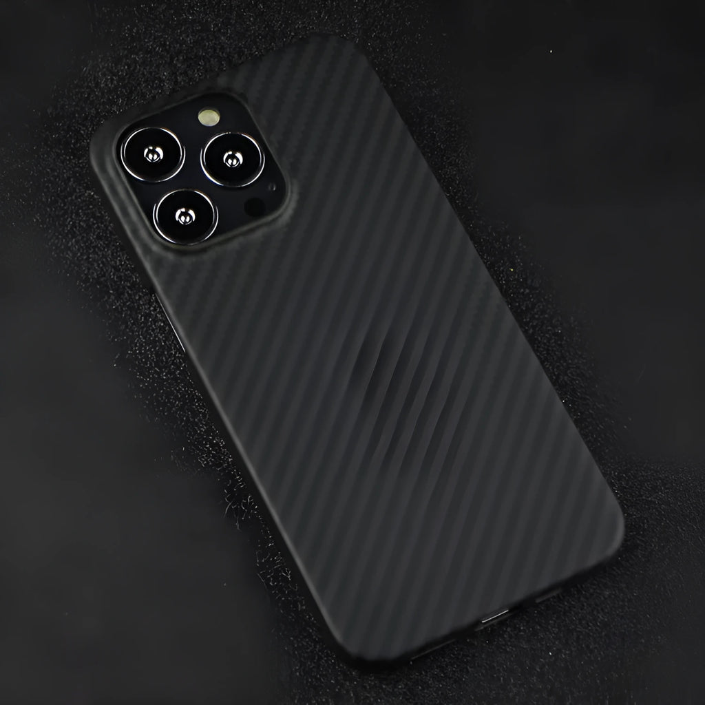 Dull black Kevlar fibre iPhone case with stripe detail and Magsafe magnet on a table.