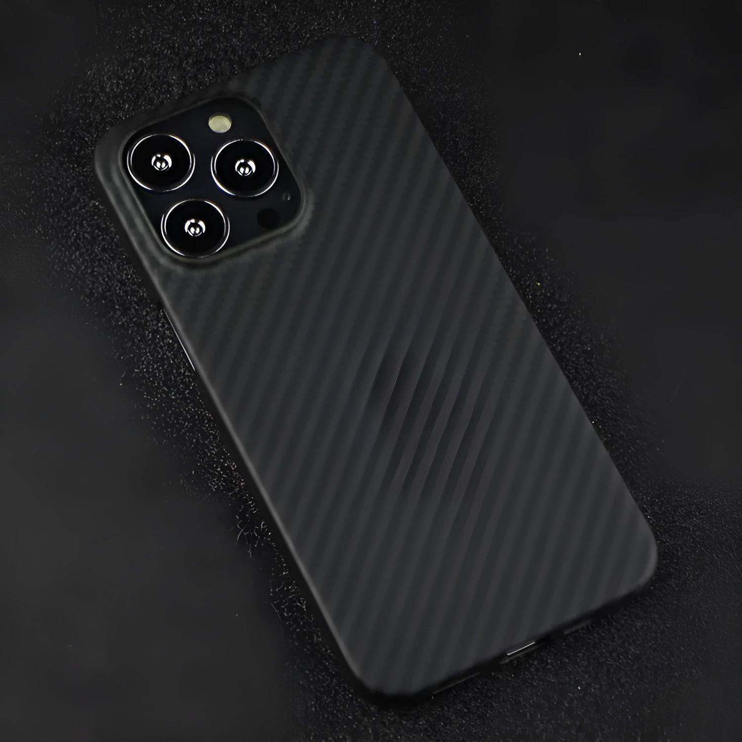 Dull black Kevlar fibre iPhone case with stripe detail and Magsafe magnet on a table.