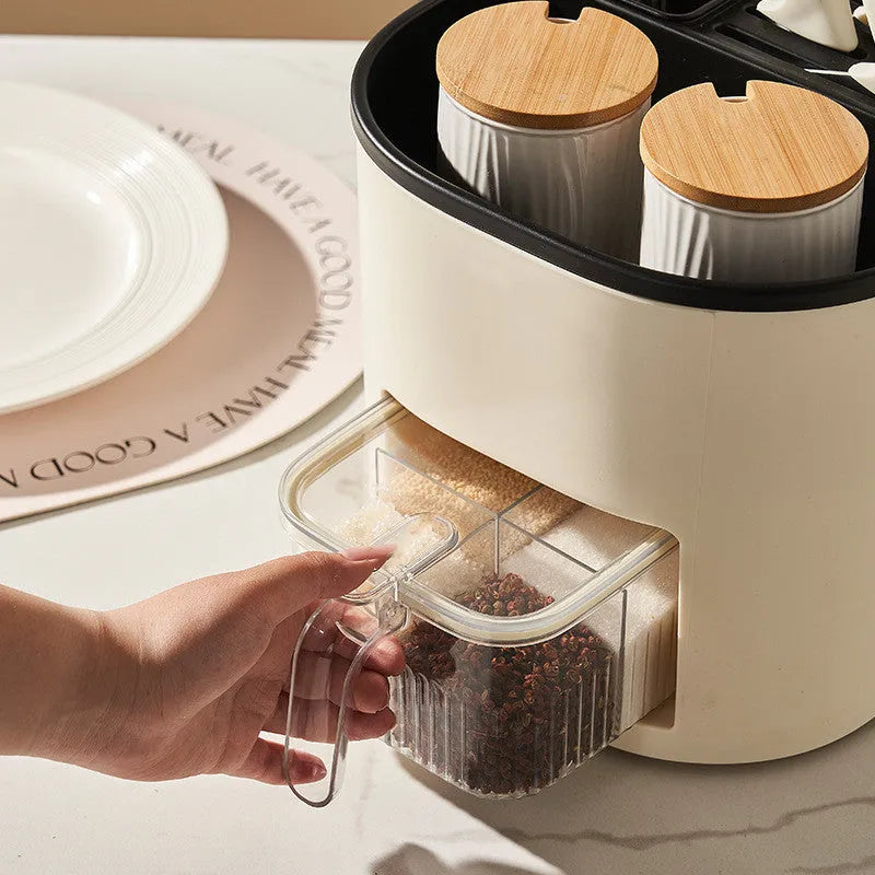 White rotating kitchen storage bucket with four-compartment spice box lid next to cutlery.