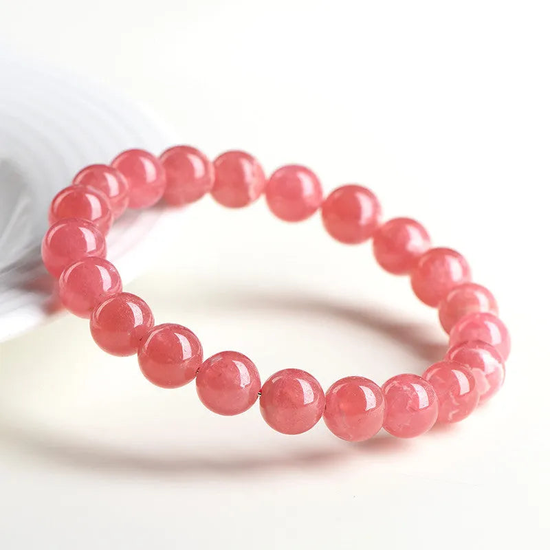 Close-up of a women's geometric red crystal bracelet with a longevity lock on a wrist.
