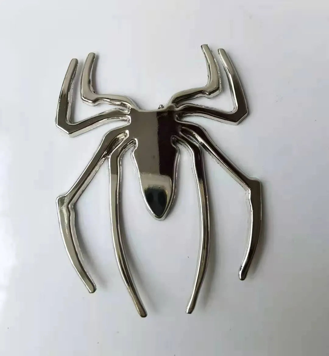 Three-dimensional metallic spider sticker in gold, silver, black, and red colours