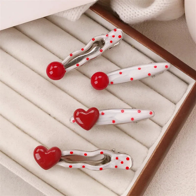 Red handmade hair clip shaped like a 3D love heart with vintage white dots, on a white background.