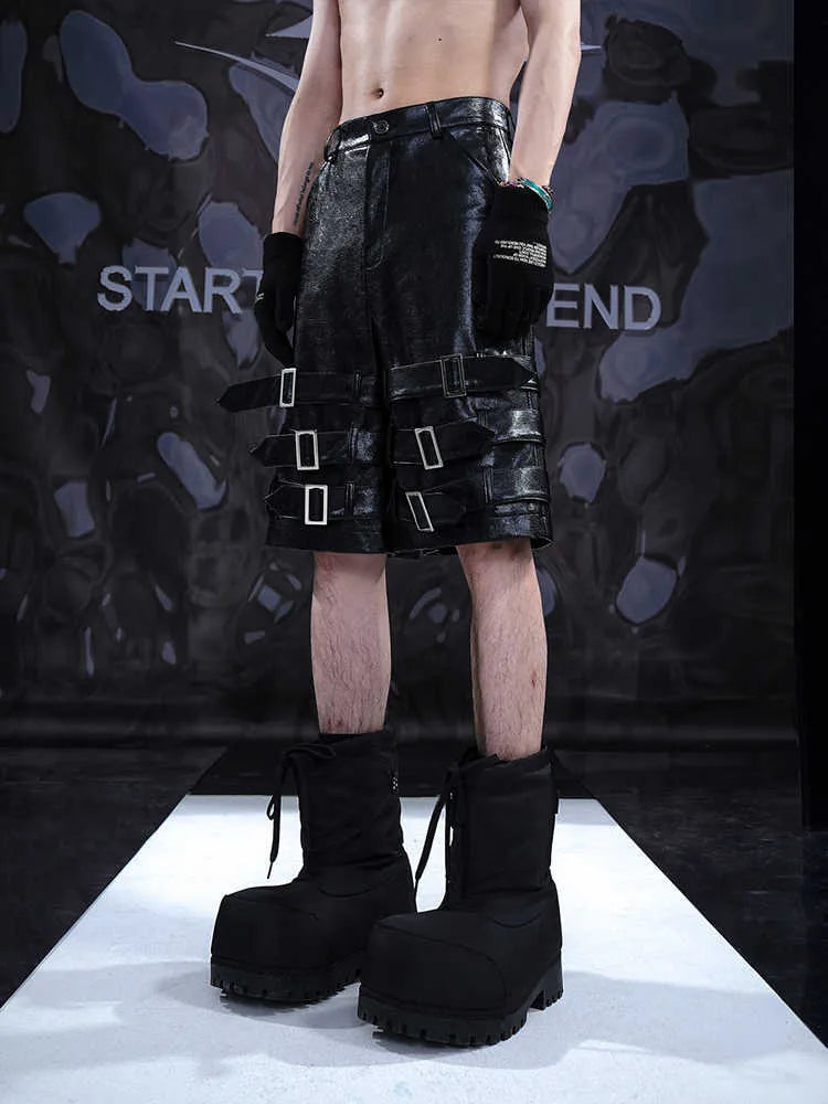 Men's black PU leather cropped pants with a ring detail on low-waist shorts.