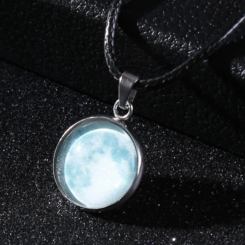 Close-up of a luminous alloy necklace with a glass pendant featuring a Christmas moon night sky and constellation design.