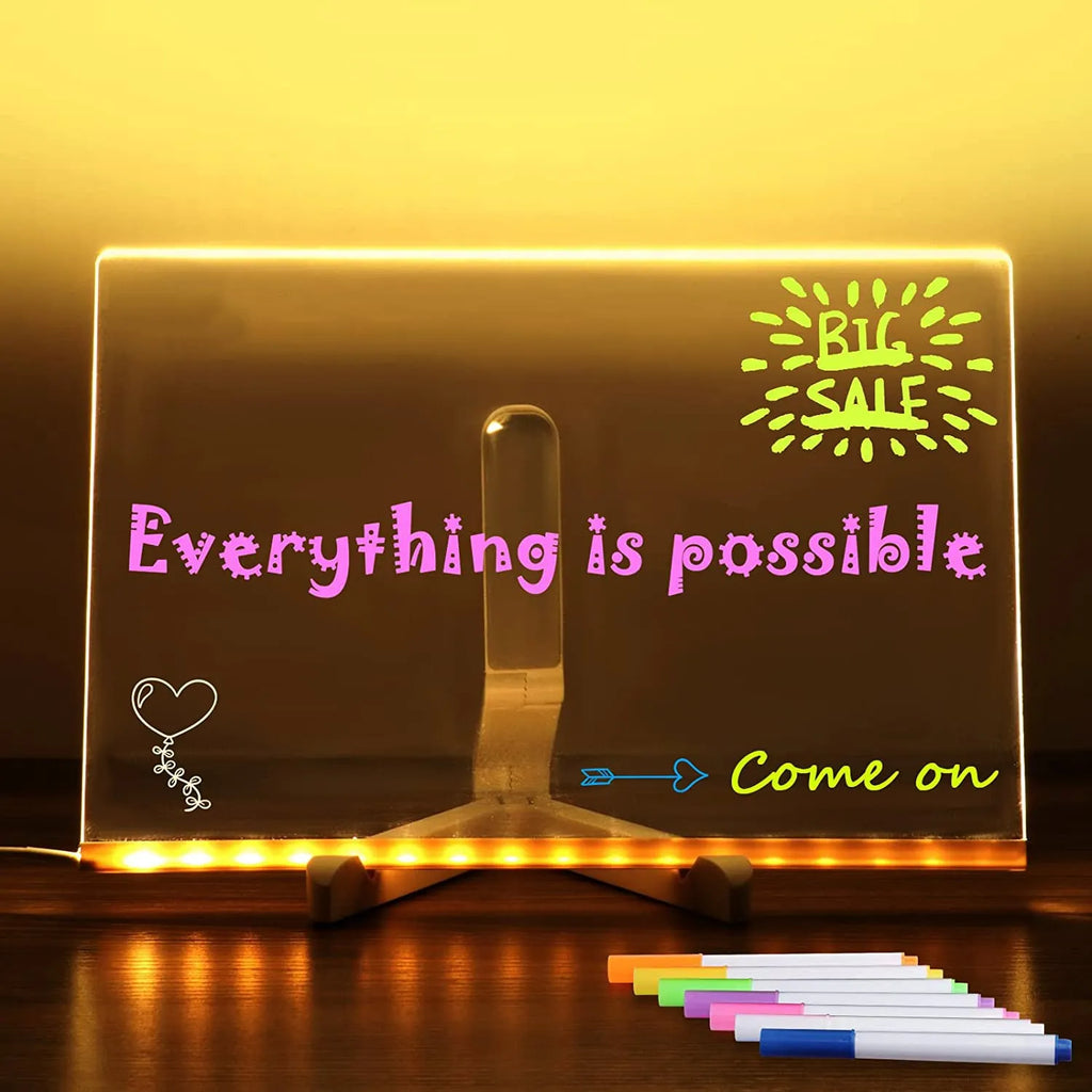 DIY acrylic LED message board on a desk with handwritten notes, glowing softly, next to colourful pens.