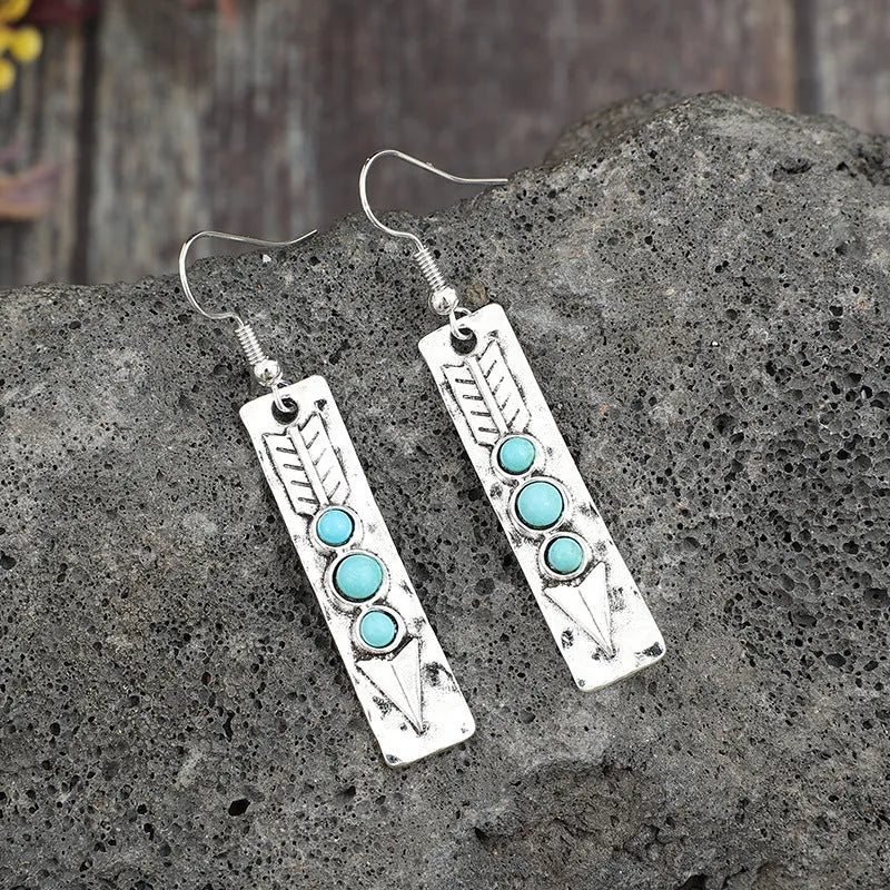 Silver long strip geometric earrings with turquoise inlay, showing front view.