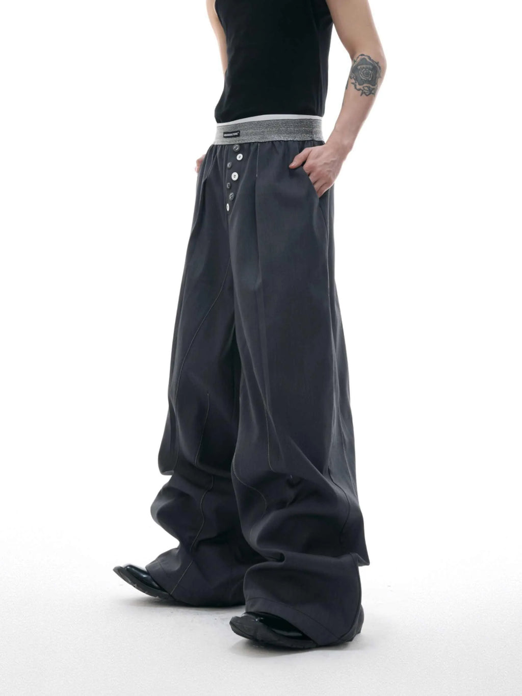 Drooping straight suit pants in black or grey with a high waist and button-open line detail.
