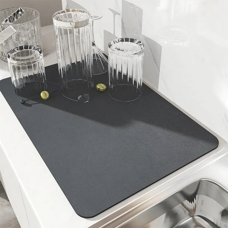 Square kitchen drain pad mat with black PU leather surface showing liquid absorption and rubber anti-slip backing