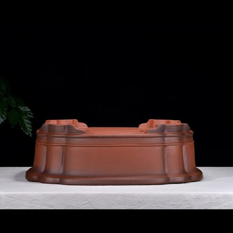 Large antique-style Chinese purple clay flowerpot with tree stump and floral relief pattern.