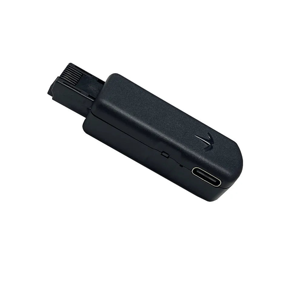 Black JB Tool USB adapter with Ethernet port for PlayStation consoles on a grey background.