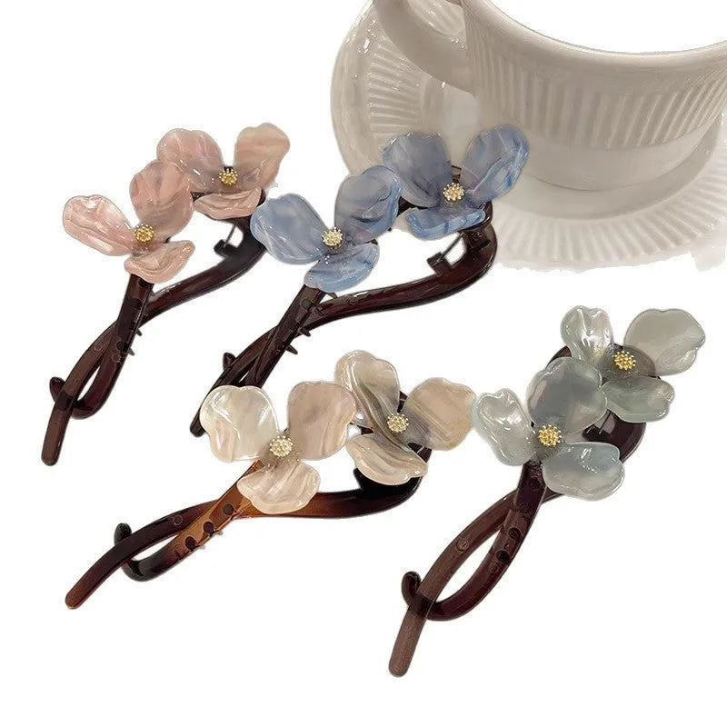 Close-up of a retro-style floral bobby pin hair clip with acrylic petals in a choice of colours.