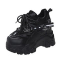 White women's low-top platform sports shoes with a cross-strap over a shallow-cut collar and a thick rubber sole.