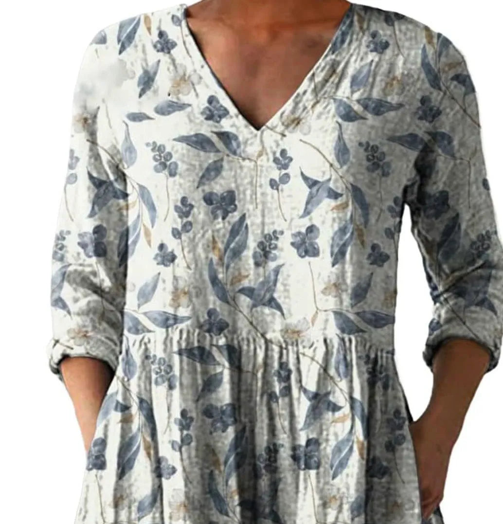 A woman wearing a loose-fit printed wave dress with 3/4 sleeves, showcasing the wide waist design.