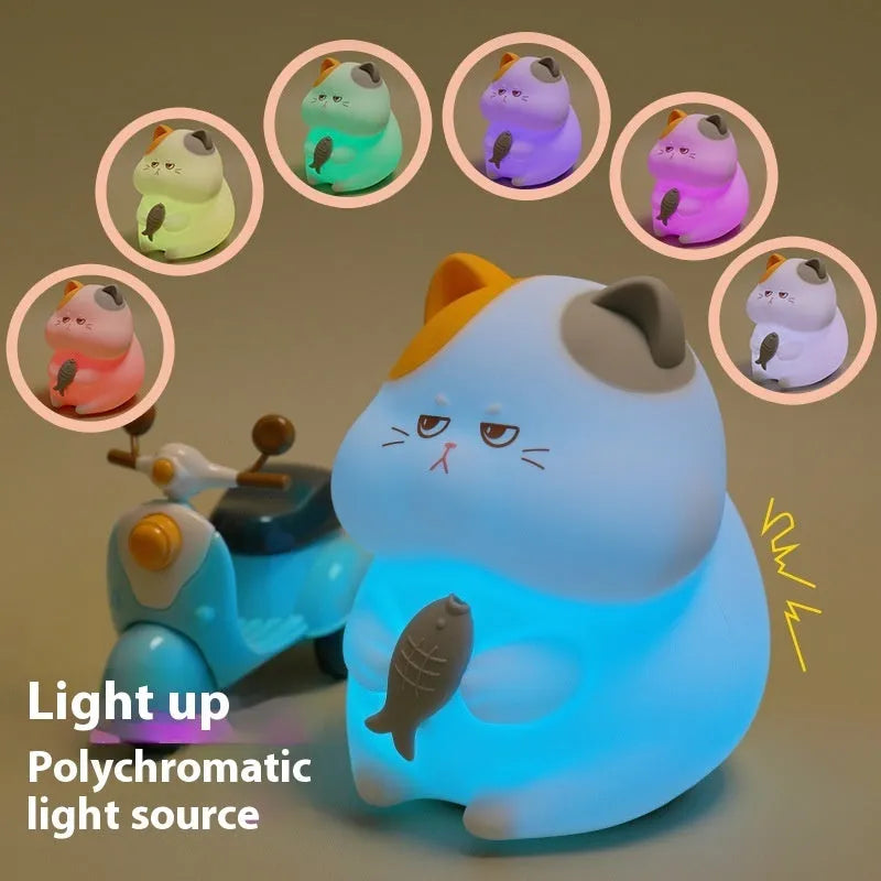 Yellow Greedy Cat cartoon desktop night light with USB cable on a wooden desk.