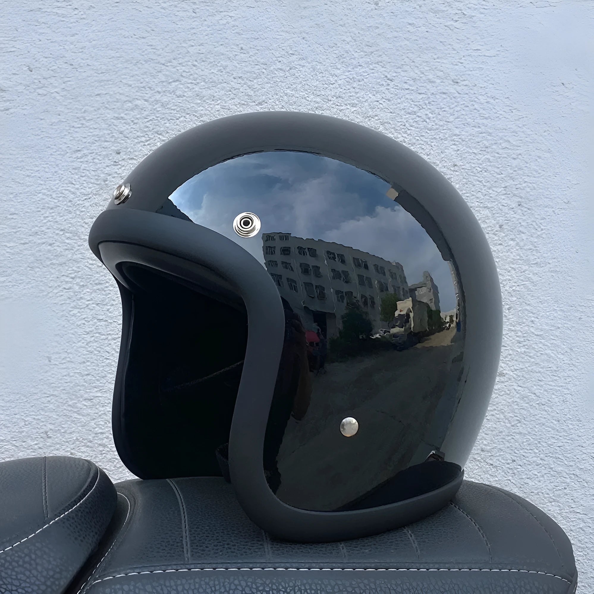 Retro-style half motorcycle helmet in fibreglass, shown in Cement Grey colour on a stand.