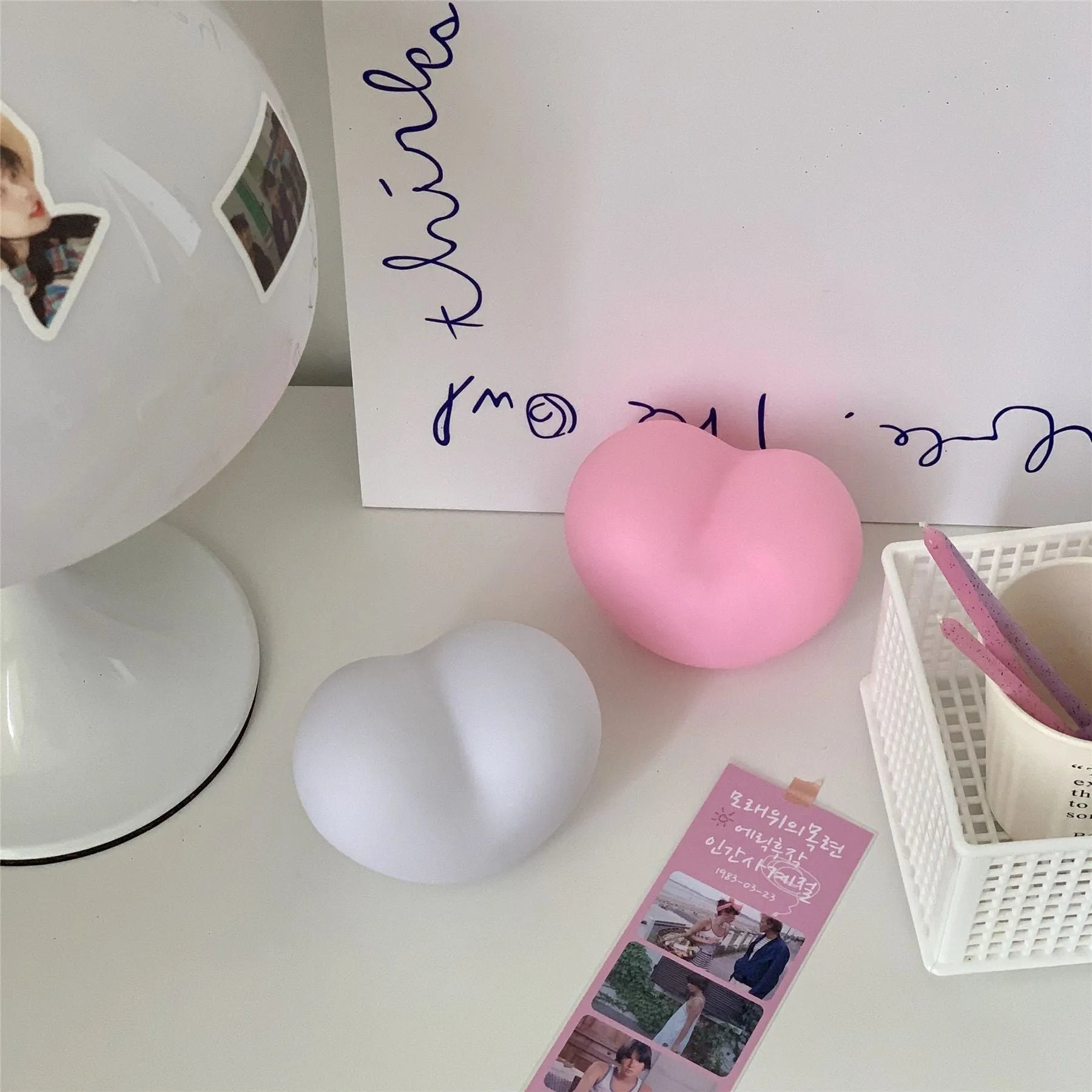 White and pink vinyl atmosphere lamp in trumpet and tuba shapes on a bedside table.