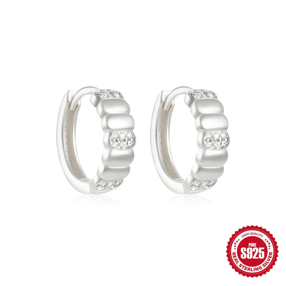 A pair of sterling silver geometric stud earrings with small round accents, shown in gold plating.