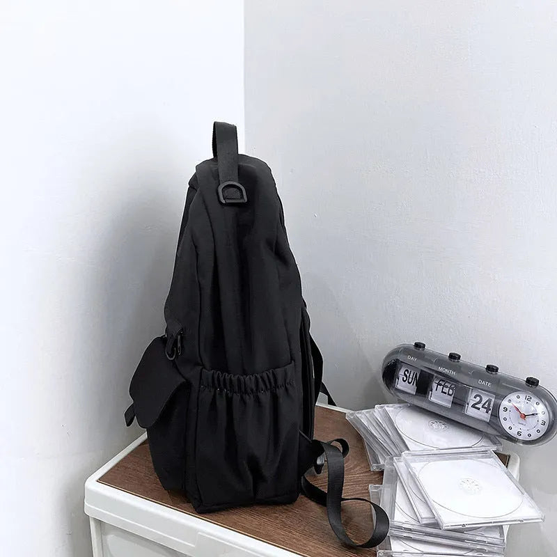 Nylon backpack school bag for junior high students, large capacity 20-35L, waterproof, with computer pocket, available in black.