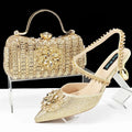 Women's black high-heel ankle boots with chain buckle flower decoration and a matching hard clutch bag.