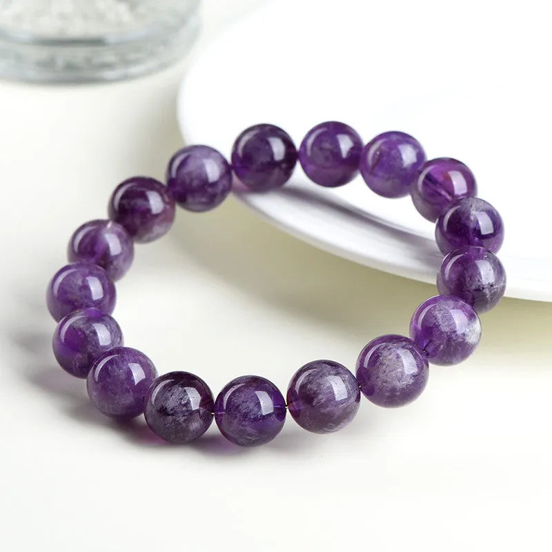 Snow mountain purple feather amethyst crystal bracelet with scattered beads and Ruyi pattern on a wrist.
