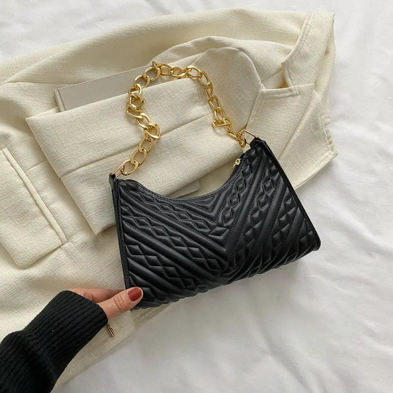 A structured black pleated women's shoulder bag with a chain strap and a soft handle, showing its square shape.