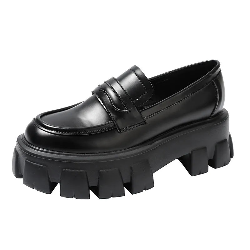 A pair of British style wide fit loafers in either matte or glossy patent leather with a shallow opening and rubber sole.