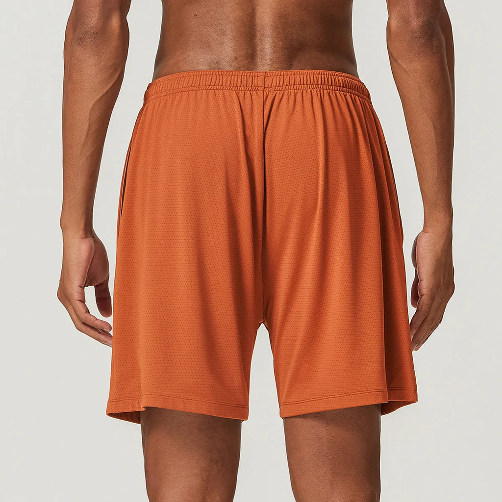 Man wearing brick red double-layer running shorts with a moisture-wicking fabric and inner compression liner.