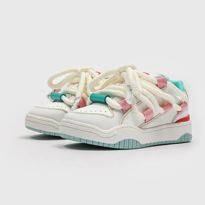 Pair of low-top unisex casual sneakers with thick flat rubber sole and lace-up front in a solid colour.