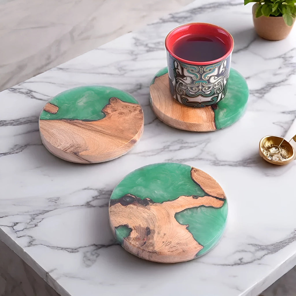 A solid black round resin coaster for a tea set, 9.8cm across and 1cm thick, on a wooden surface.