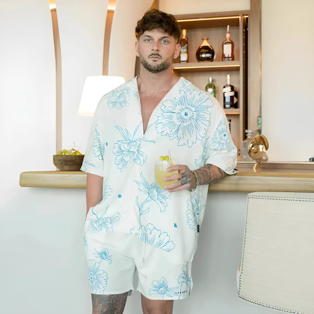 Man's loose-fitting printed short sleeve top in a light colour, showing cardigan style and floral pattern detail.