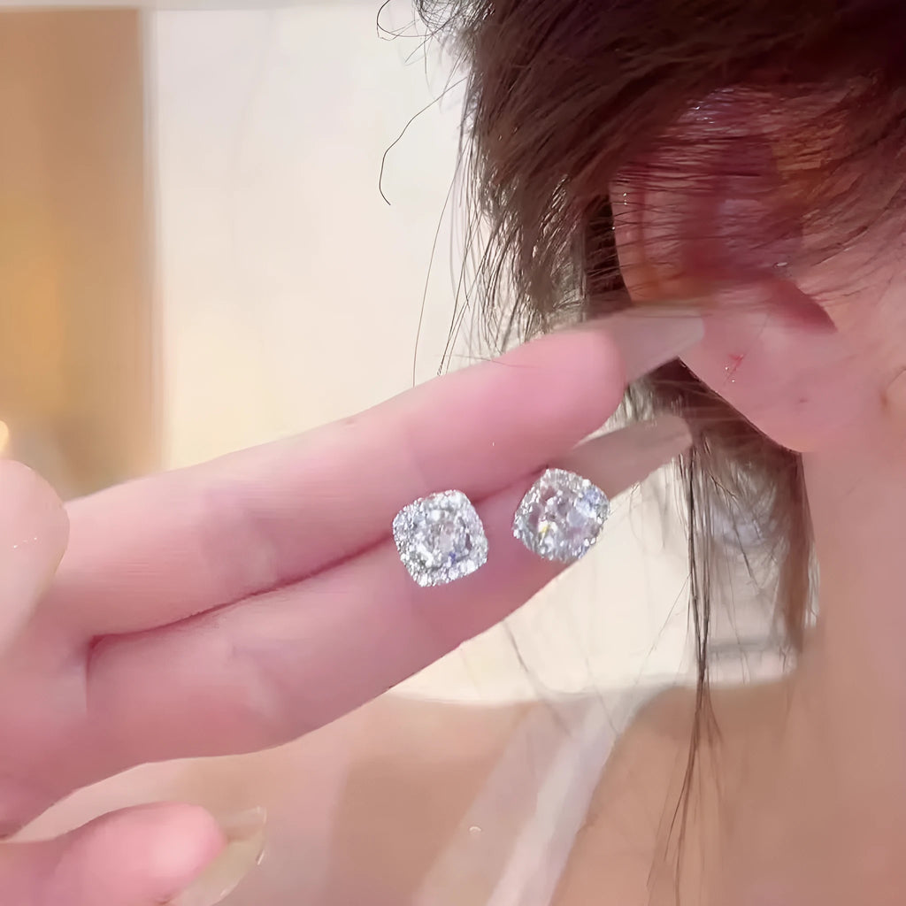 A pair of women's geometric square earrings with a central diamond stone, in an alloy silver or gold finish.