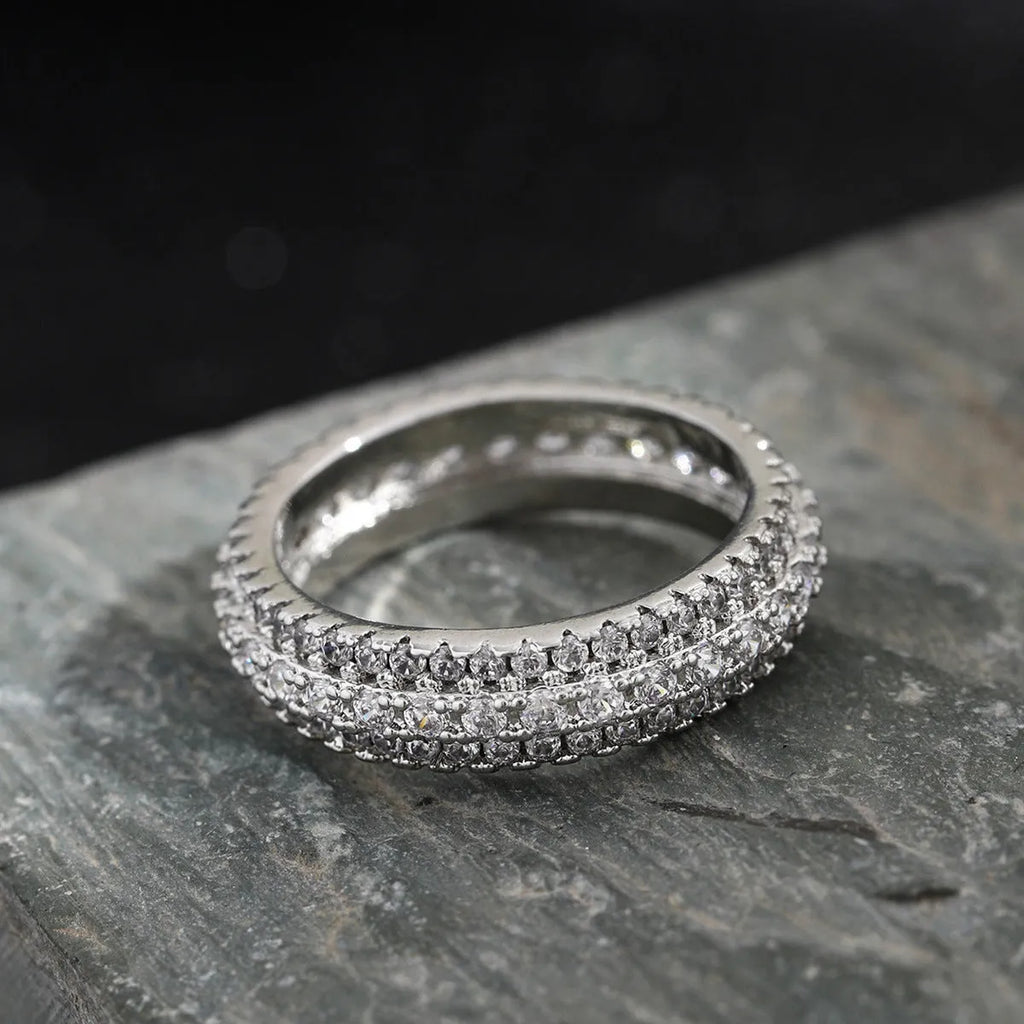 Triangular geometric ring with a zircon stone centre, shown in different metal plating colours.