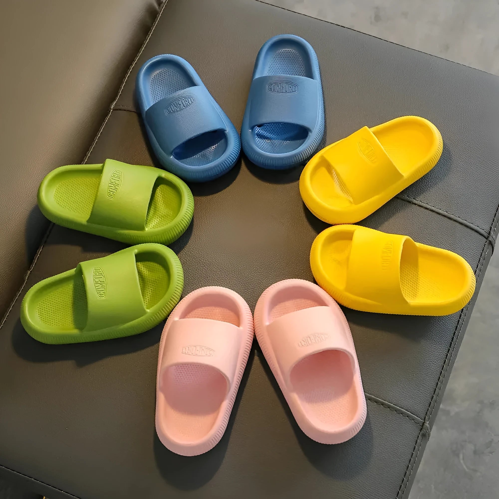 Children's mixed colour EVA slippers with textured sole, shown in blue, green, orange, pink, and yellow.