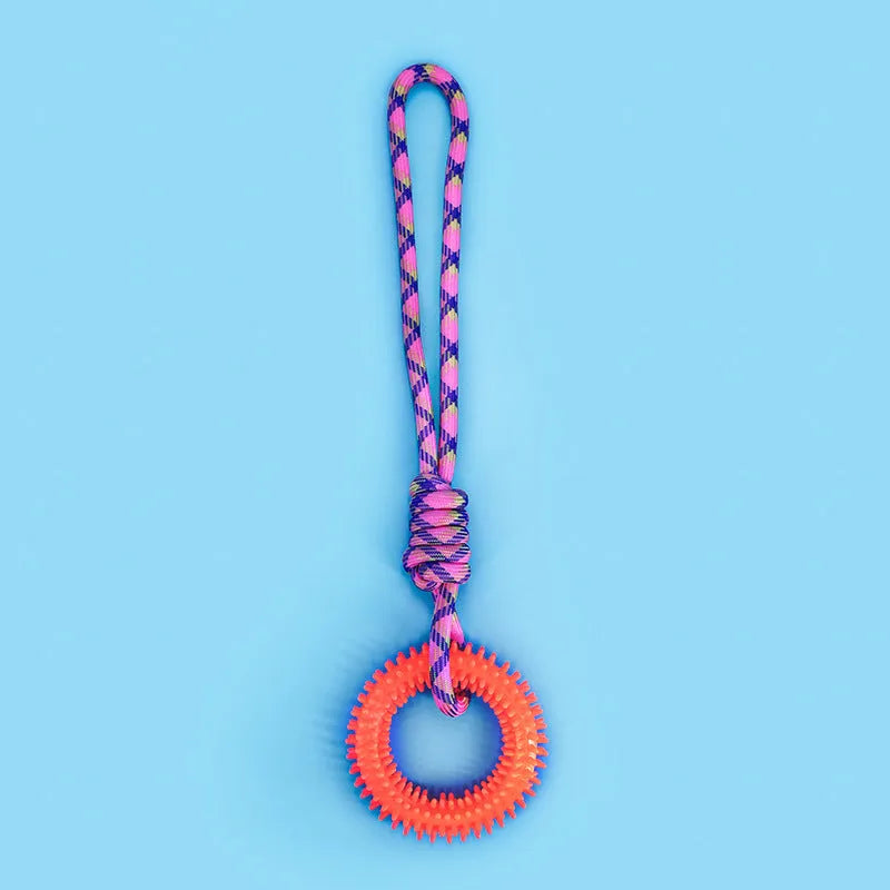 Blue, red, and rose red braided rope dog toy with a large central knot.