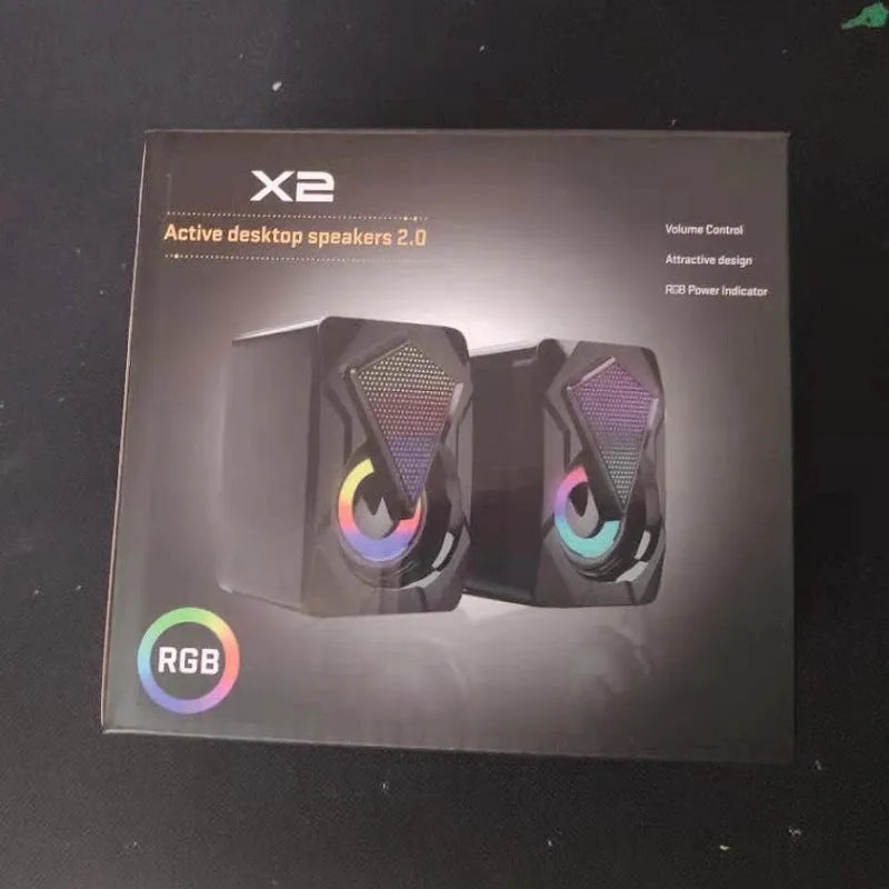 X2 RGB USB desktop multimedia speaker pair with extra bass, wired connection, and colourful lighting on a desk