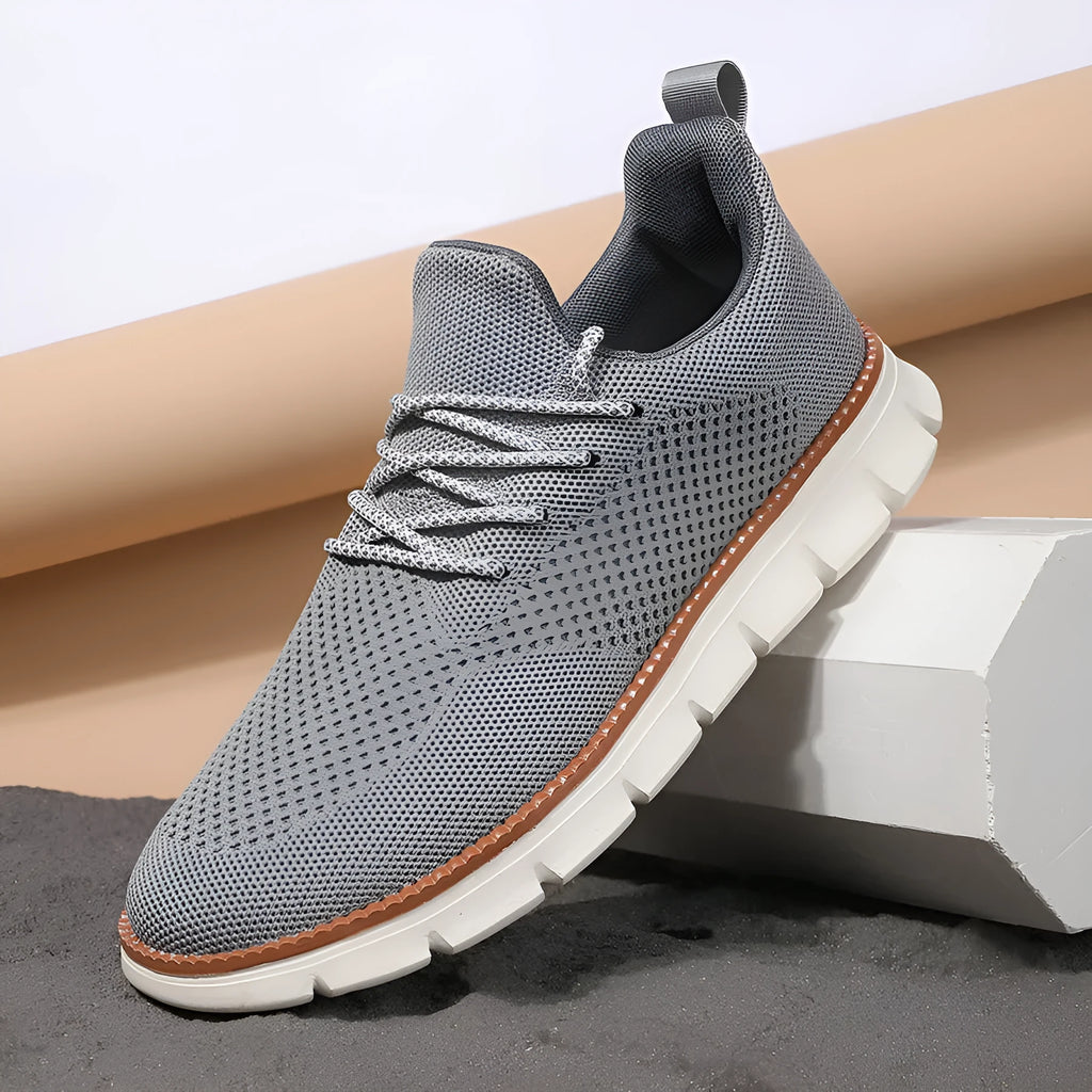 Men's grey and black mesh fabric casual sneakers with a round toe and low heel on a plain background.
