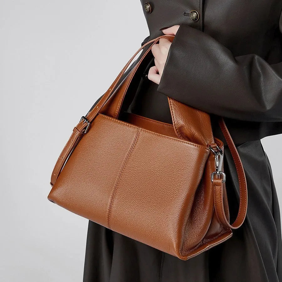 Women's genuine cowhide messenger bag with retro texture in horizontal square design showing shoulder straps and exterior pocket