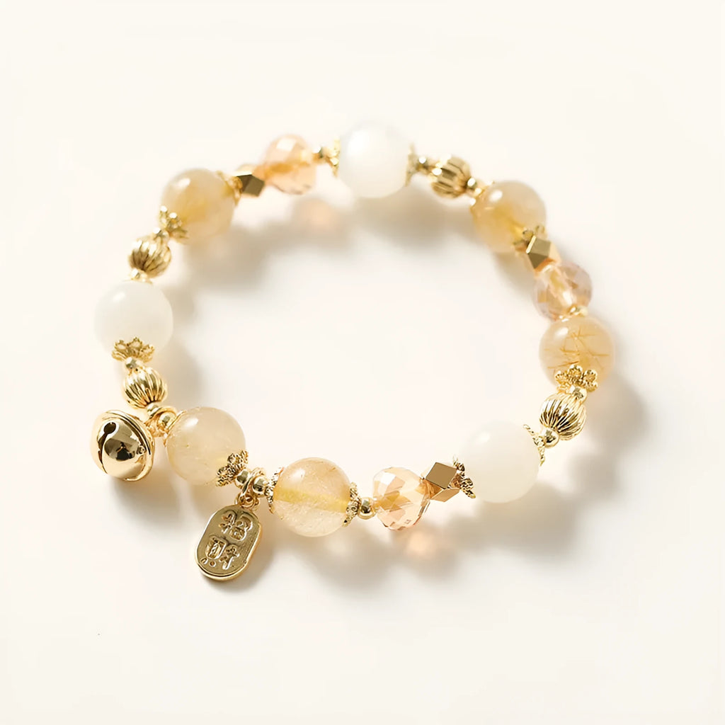 Gold rutilated quartz crystal bracelet with a ringing bell charm in Korean style.