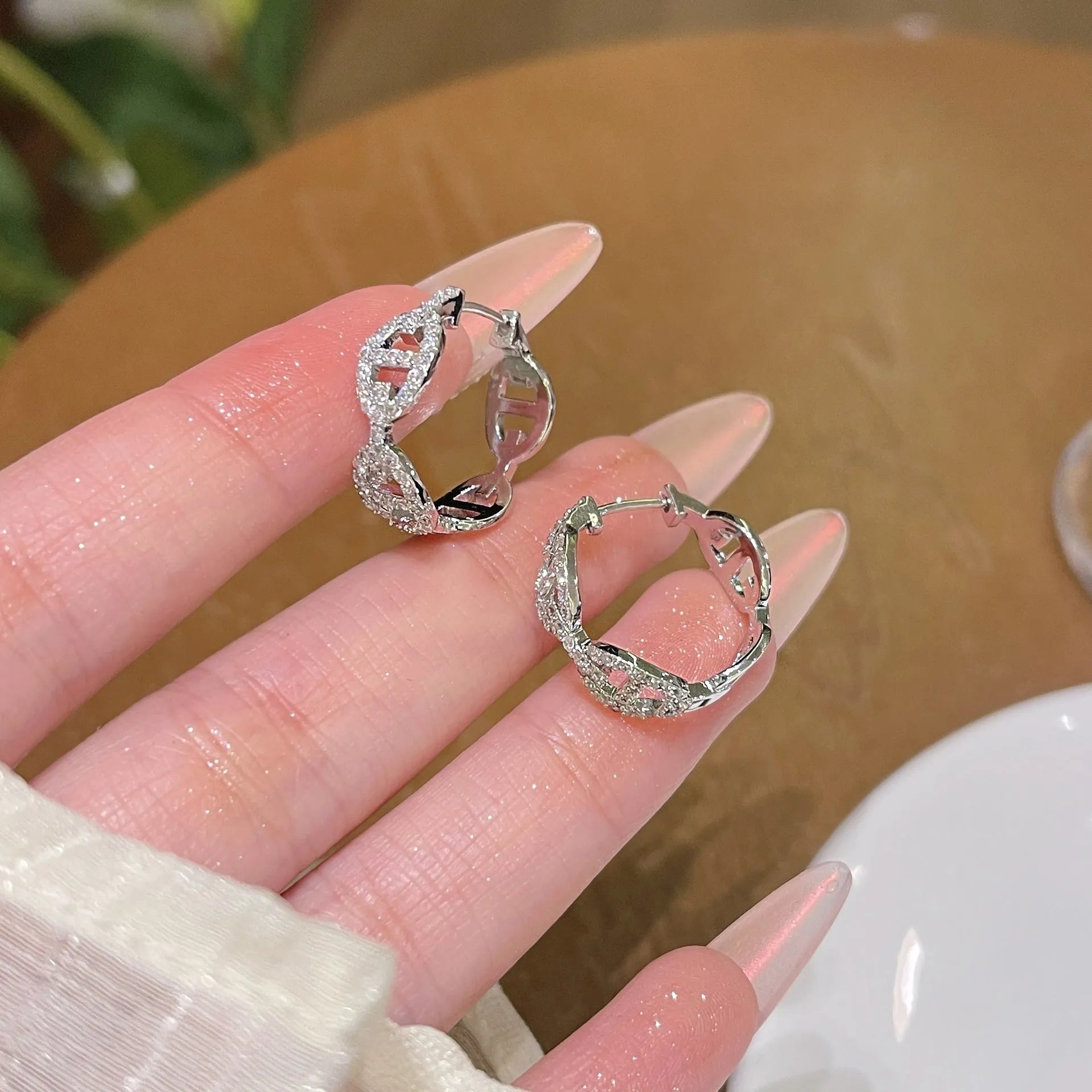 A pair of casual ladies earrings with a diamond-like detail, shown in an electroplated silver, gold, or rose gold finish.