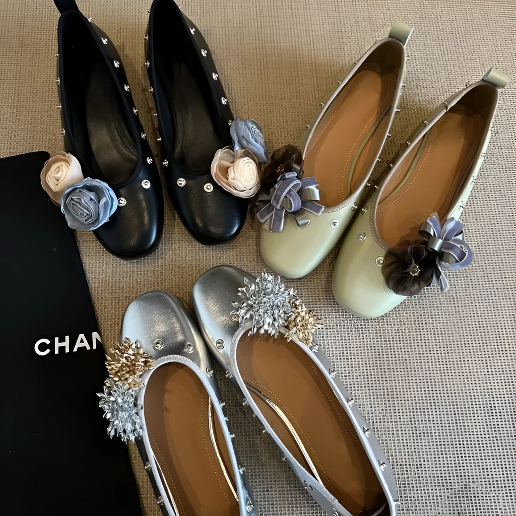 Women's silver Mary Jane loafers with flower rivets, buckle strap, round toe, and flat rubber sole.